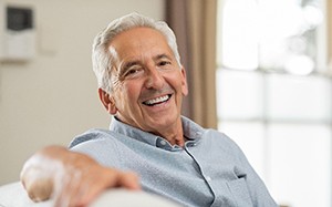 Older man with dentures sitting on couch