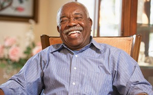 Man smiling from the comfort of his armchair