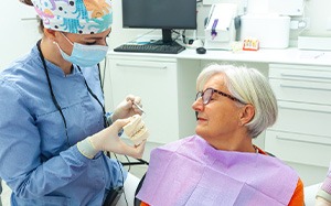 Older woman looking at new smile while learning about dental implant post-op instructions in Bothell