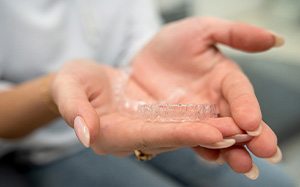 Closeup of patient holding clear aligners