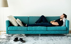Man asleep on the couch with head elevated