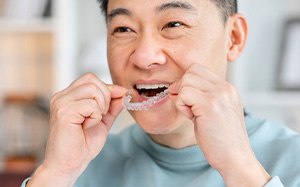 Patient putting on clear aligner