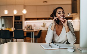 Woman smiling while talking on phone at home