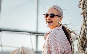 Older woman showing off dental implants while on a boat