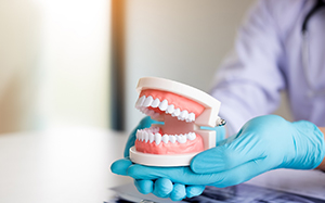 dentist holding removable dentures