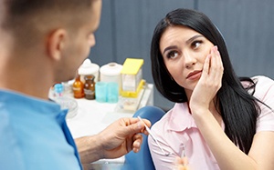 Woman with tooth pain holding jaw in discomfort 