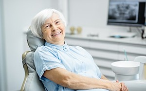 Woman smiling while sitting in patient’s chair