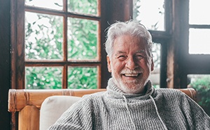 Man smiling in a room with lots of windows