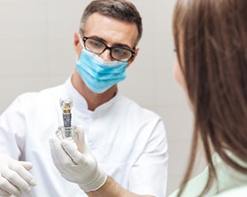 Dentist showing patient implant crown model