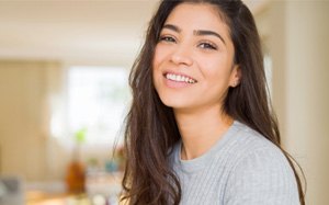 young woman smiling inside home 