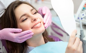 woman smiling in dental mirror 