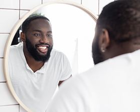 Man with veneers smiling in reflection