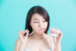 Woman choosing between Invisalign and traditional braces.