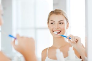 Woman brushing to prevent oral health problems in Bothell. 