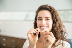 Woman using Invisalign on the top teeth