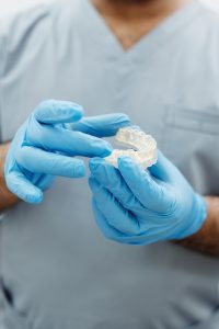 Dentist holding dental mold and clear aligner