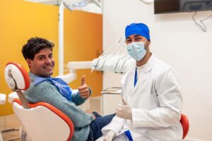 Dentist and patient making thumbs-up sign